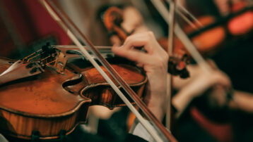 Close-up van een violist tijdens een klassiek concert, spelend in een orkest – voor de Thomann blog: 10 klassieke meesterwerken die je moet kennen
