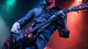 Gitarist speelt krachtige riff op elektrische gitaar tijdens live optreden