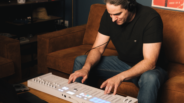 Beginnende muzikant speelt op een MIDI-keyboard in een thuisstudio-opstelling, voor blog "Zo kies je je eerste MIDI-keyboard".