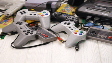 De Meest Epische Videogamesoundtracks aller tijden: Een verzameling vintage videogamecontrollers en cartridges van klassieke consoles zoals NES, Sega en PlayStation