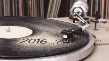 Stoffige vinylplaat op een draaitafel met de tekst “2016”, als symbool voor artiesten die al meer dan tien jaar geen album hebben uitgebracht.