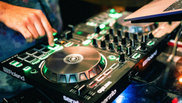 Beginner die een DJ-controller gebruikt met jogwheels en performance pads om muziek te mixen