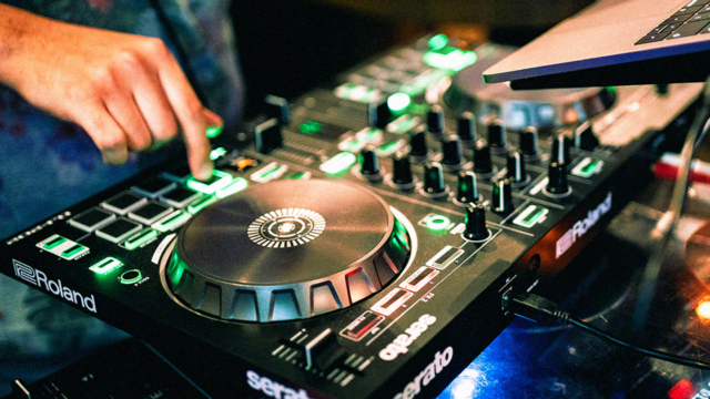 Beginner die een DJ-controller gebruikt met jogwheels en performance pads om muziek te mixen