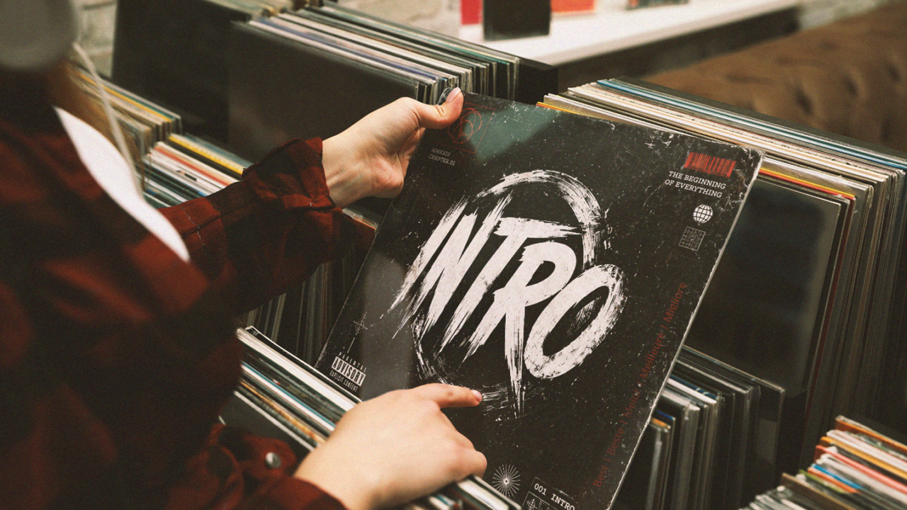 Iemand bladert door een collectie vinylplaten en houdt een platenhoes met het woord 'Intro' vast. De afbeelding staat symbool voor de meest iconische songintro's uit de muziekgeschiedenis.