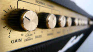 Close-up van de regelaars van een gitaarversterker met gain- en EQ-instellingen.