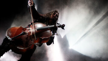 Een cellist treedt live op tijdens een rockconcert en laat zien hoe belangrijk strijkinstrumenten zijn binnen de moderne rock- en popmuziek.
