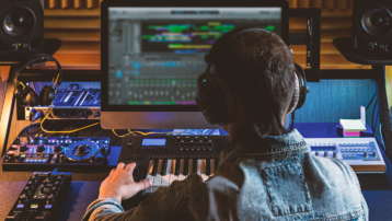 Muziekproducer aan het werk in een homestudio met studiomonitoren, MIDI-keyboard en audioapparatuur